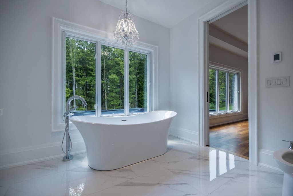 Bathroom with a freestanding tub and a large window